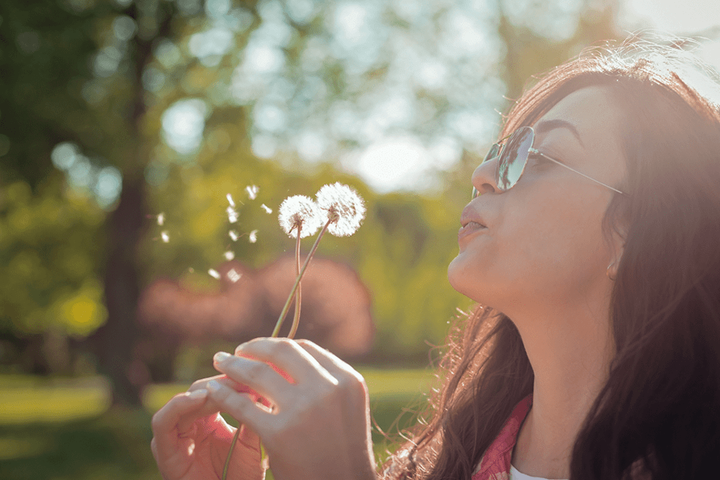 allergies - girl blowing flowers