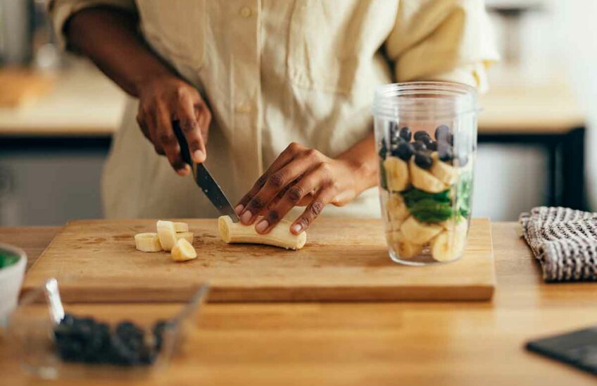 Close up of hands chopping bananas for a smoothie