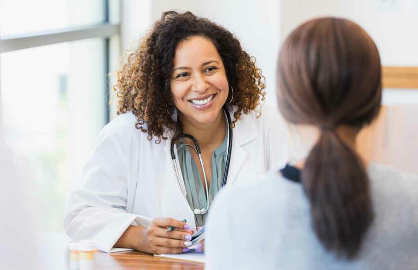 Smiling naturopathic doctor talking to a patient