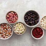A variety of types of beans in different bowls
