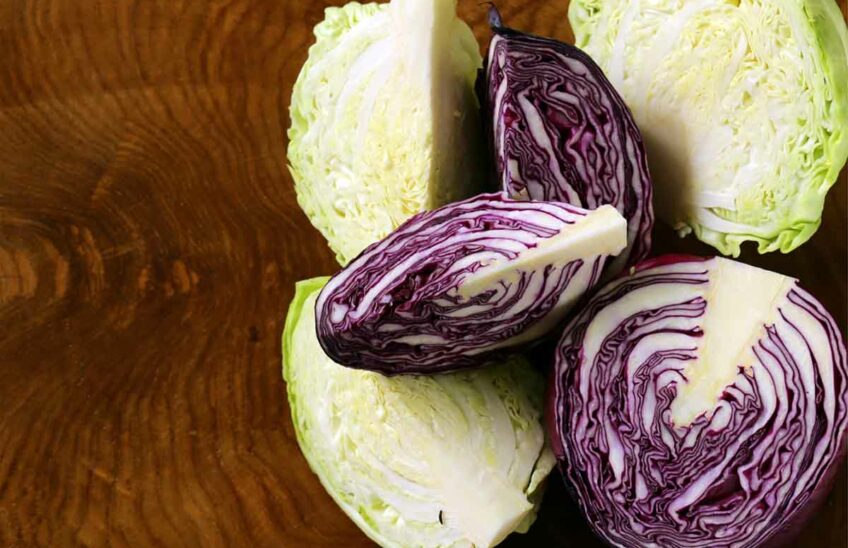 Red and green cabbage on a wooden surface